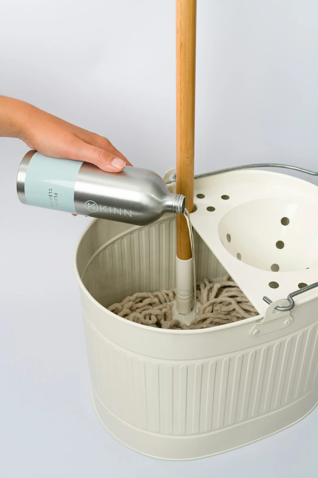 brand-01 A hand wipes a dark surface with a tissue near a paper roll and plant.