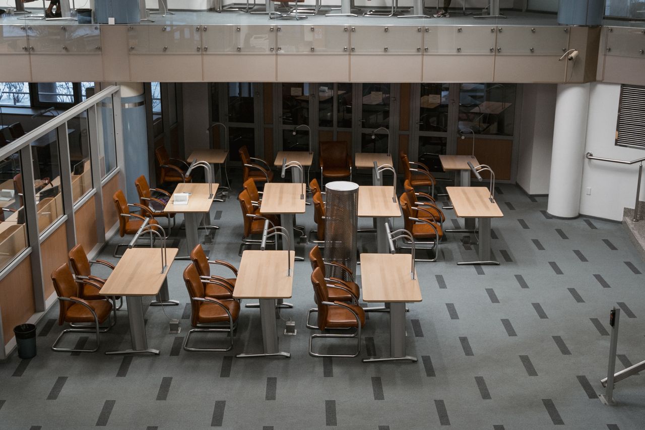 why-choose-us Intérieur de bureau lumineux et contemporain avec chaises et tables disposées, idéal pour les espaces de travail.